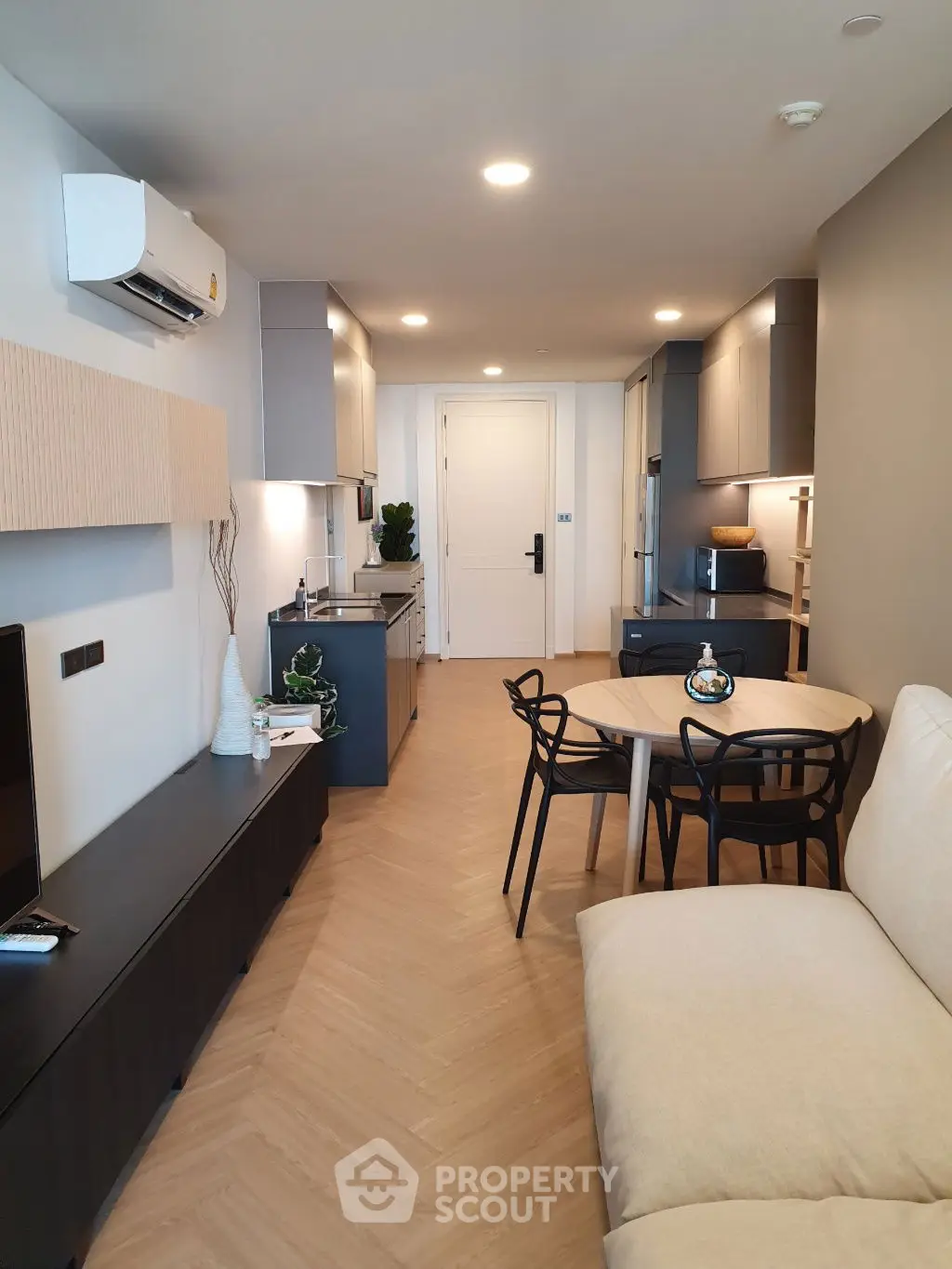 Modern open-plan living room with sleek kitchen and cozy dining area, perfect for urban living.