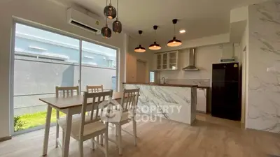 Modern kitchen with marble island and dining area in bright open layout