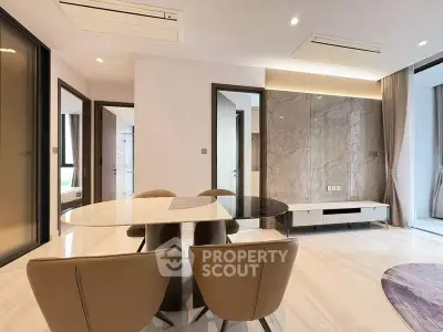 Luxurious modern dining area with elegant marble table and stylish chairs in a bright open-plan living space.