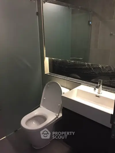Modern bathroom with sleek design featuring a glass shower and contemporary fixtures.