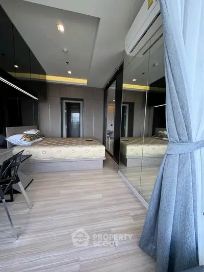 Modern bedroom with mirrored wardrobe and stylish decor in a contemporary apartment.