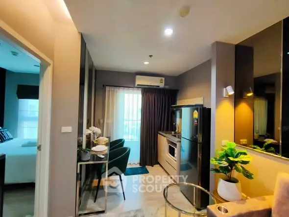 Modern open-layout living area with kitchen and dining space, featuring stylish decor and natural light.