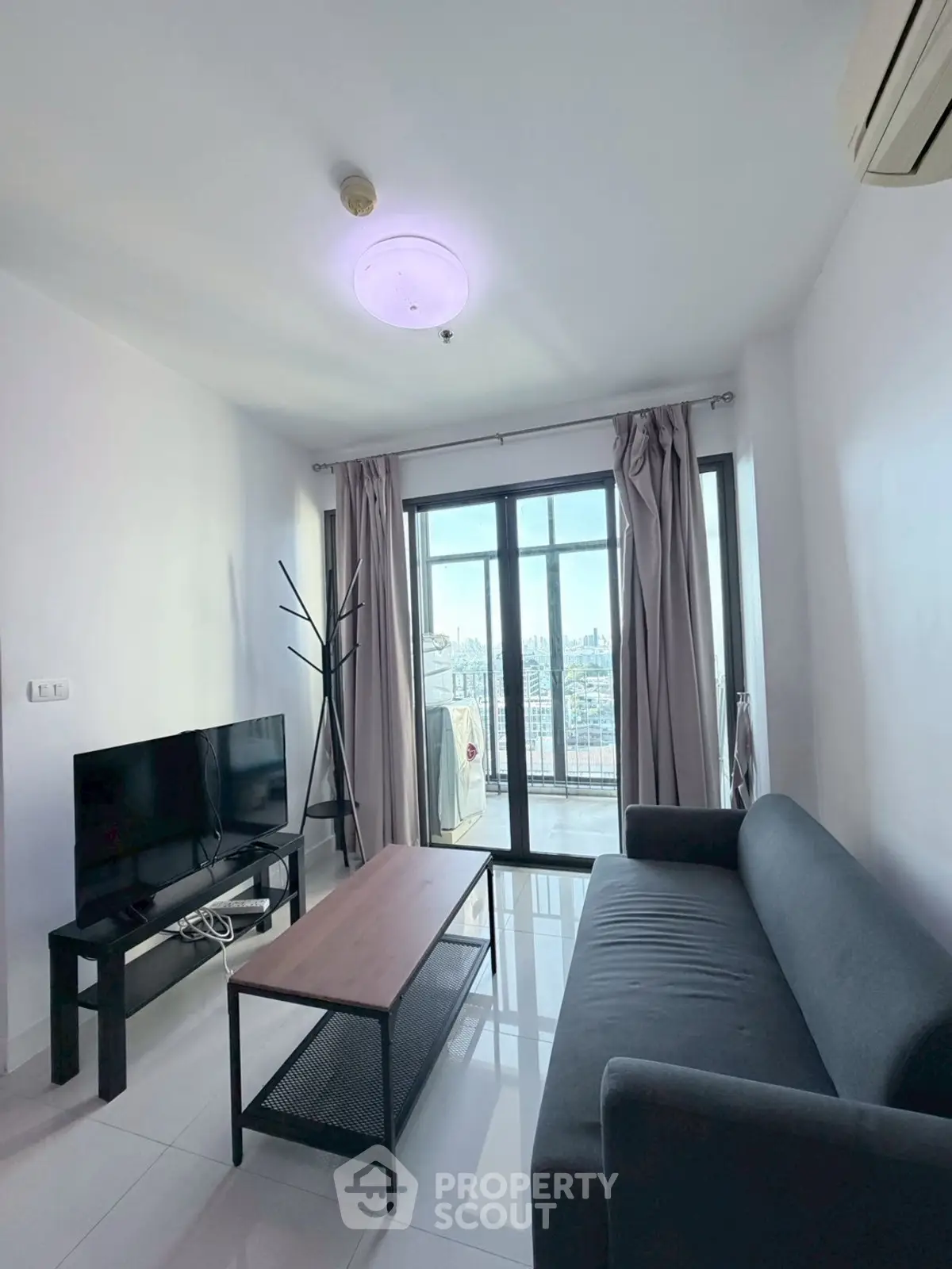 Modern living room with sleek furniture and city view balcony