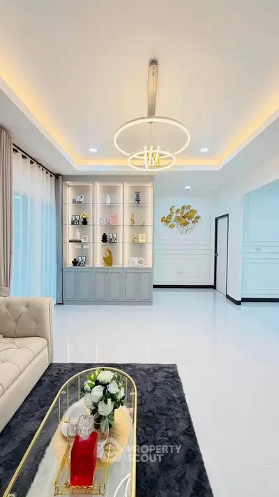 Elegant living room with modern chandelier and stylish decor in a luxurious home.