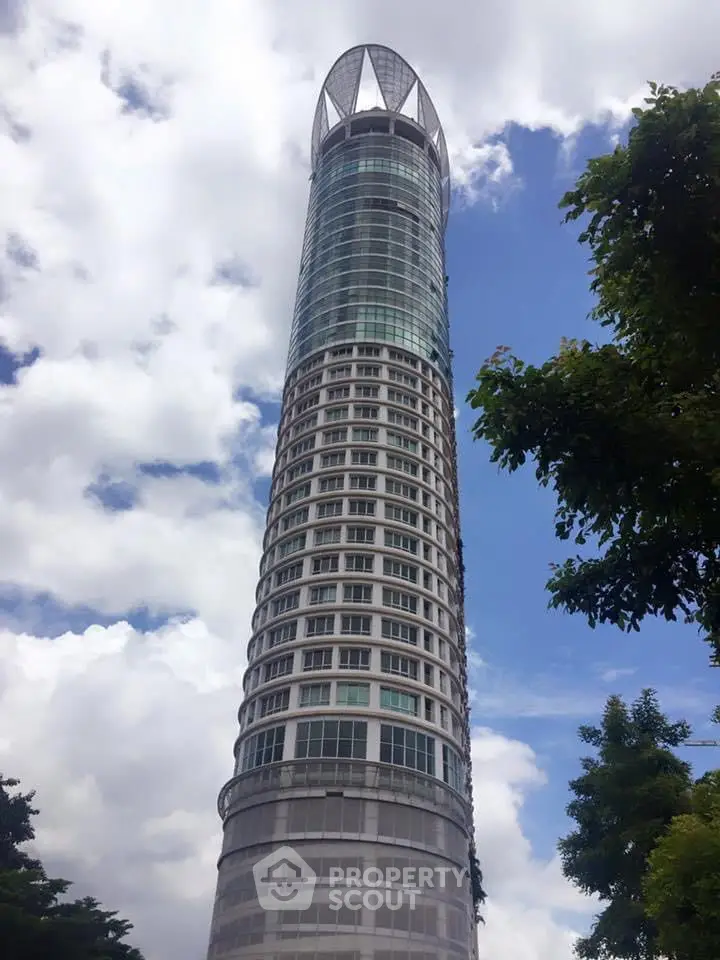 Stunning modern skyscraper with unique architectural design against a vibrant blue sky.