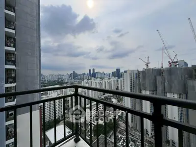 Stunning urban balcony view with city skyline and construction cranes.