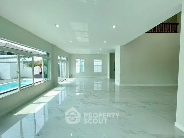 Spacious modern living room with large windows and pool view