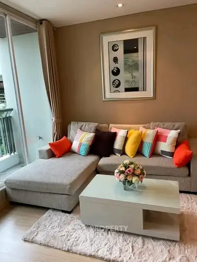 Stylish living room with modern sofa, colorful cushions, and elegant decor in a cozy apartment.