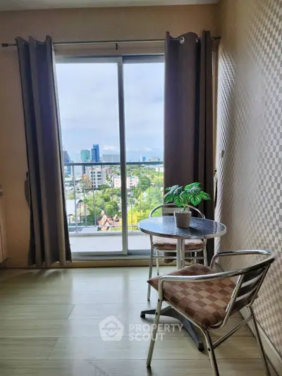 Cozy balcony with city view, featuring a small table and chairs, perfect for relaxation.