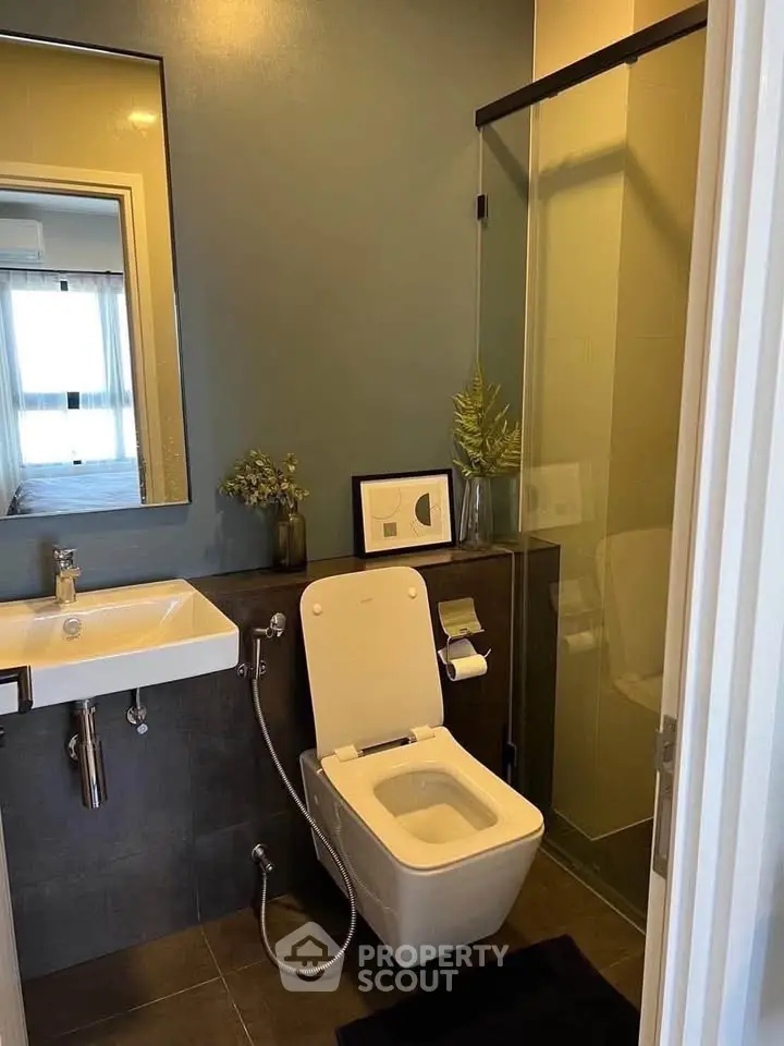 Modern bathroom with sleek design, featuring a glass shower and contemporary fixtures.