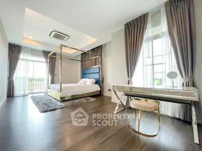 Luxurious bedroom with elegant decor and large windows offering natural light and scenic views.