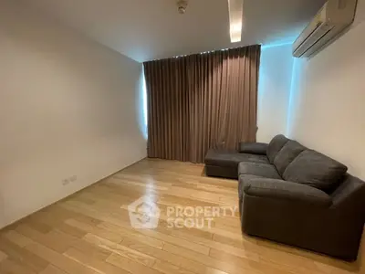 Cozy living room with wooden flooring and modern sofa, perfect for relaxation.
