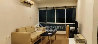 Cozy living room with modern sofa, air conditioning, and large windows for natural light.