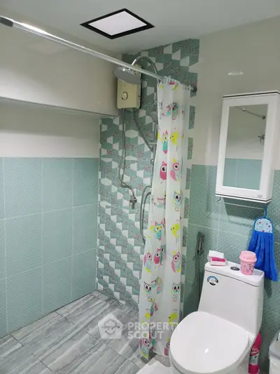 Charming bathroom with modern shower and owl-themed curtain in a cozy home.