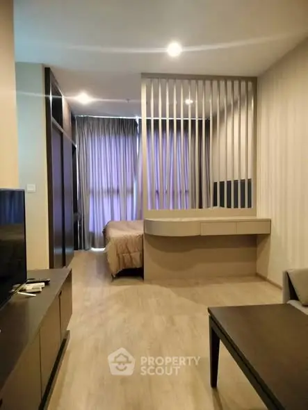 Modern studio apartment with open layout and stylish partition, featuring cozy bedroom and living area.