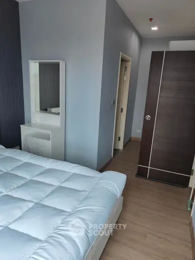Modern bedroom with sleek design and cozy bedding in a stylish apartment.