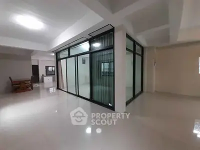 Spacious modern interior with glass partition and dining area, ideal for open-plan living.