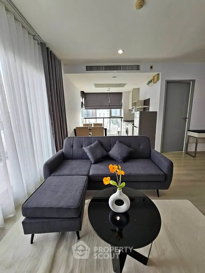 Modern living room with stylish furniture and open kitchen layout in a bright apartment.