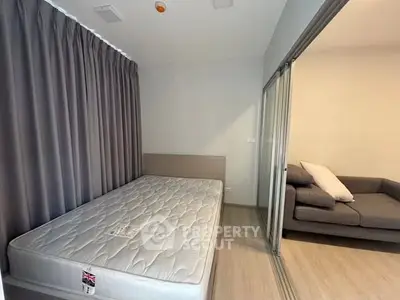 Modern bedroom with sliding glass doors and cozy living area, perfect for urban living.