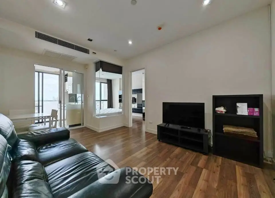 Spacious modern living room with sleek leather sofa and wooden flooring