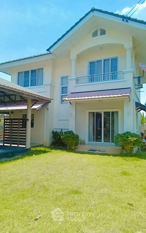 Charming two-story house with lush green lawn and elegant architectural design.