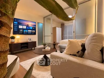 Modern living room with stylish decor and large TV, perfect for relaxation and entertainment.