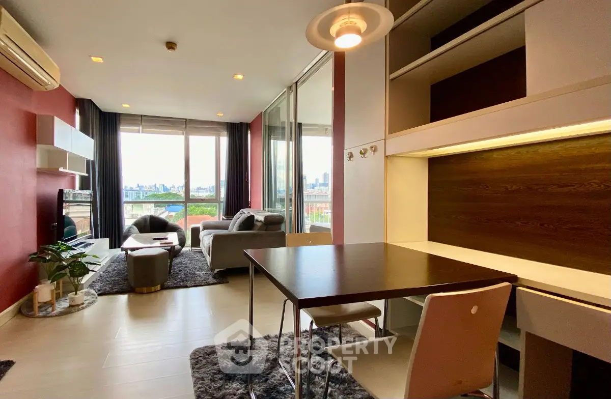Modern living room with city view, featuring stylish furniture and natural light.