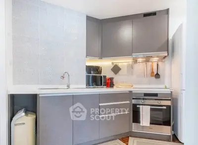 Modern kitchen with sleek cabinets and built-in appliances in a stylish apartment.