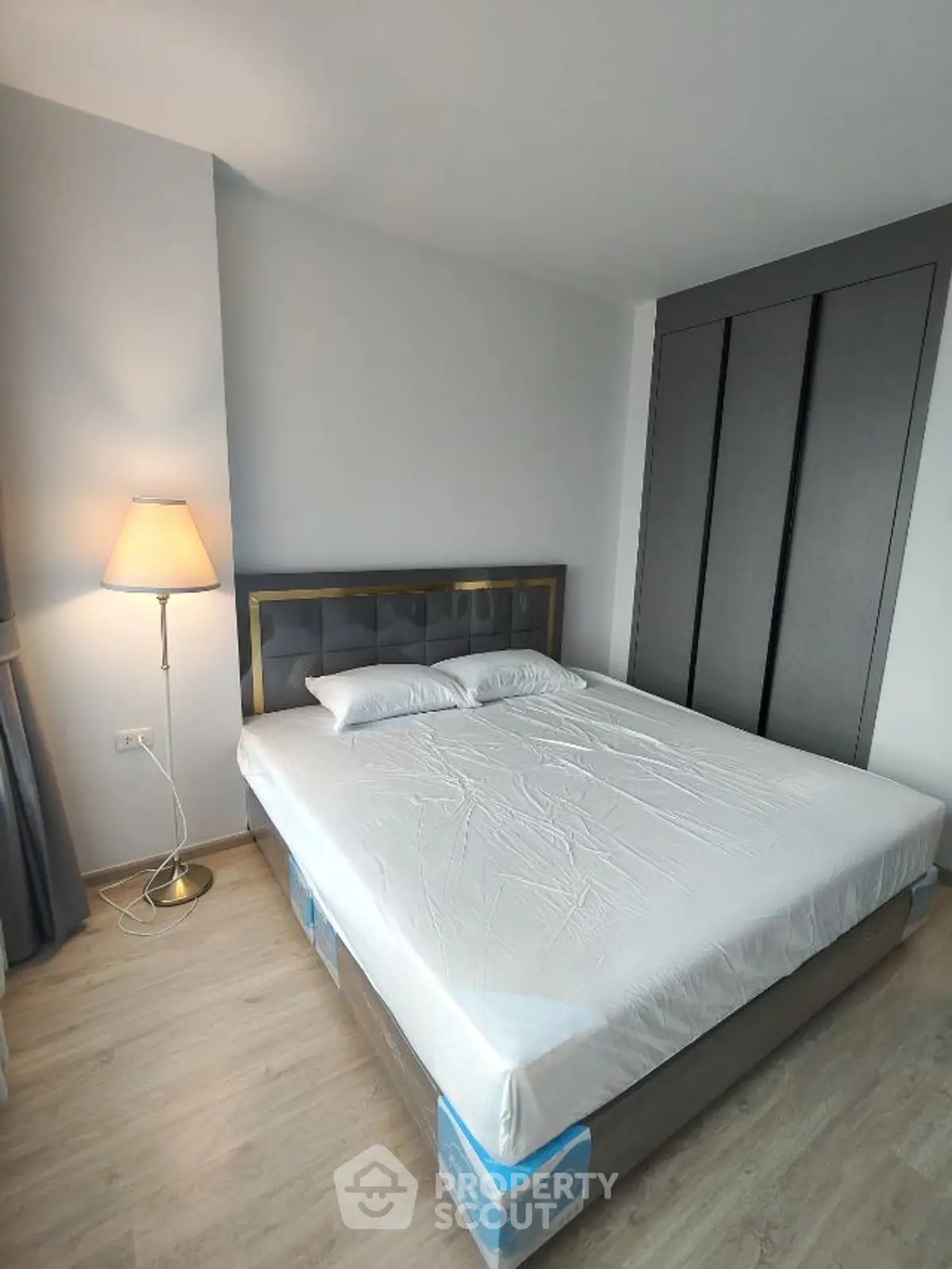 Modern bedroom with stylish bed and floor lamp in a cozy apartment