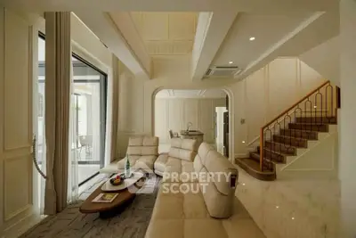 Luxurious living room with elegant staircase and modern furniture in a spacious open layout.