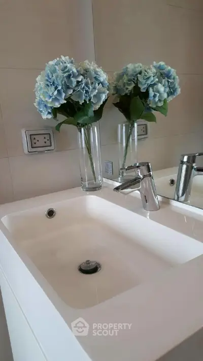 Elegant bathroom sink with stylish faucet and blue hydrangea decor