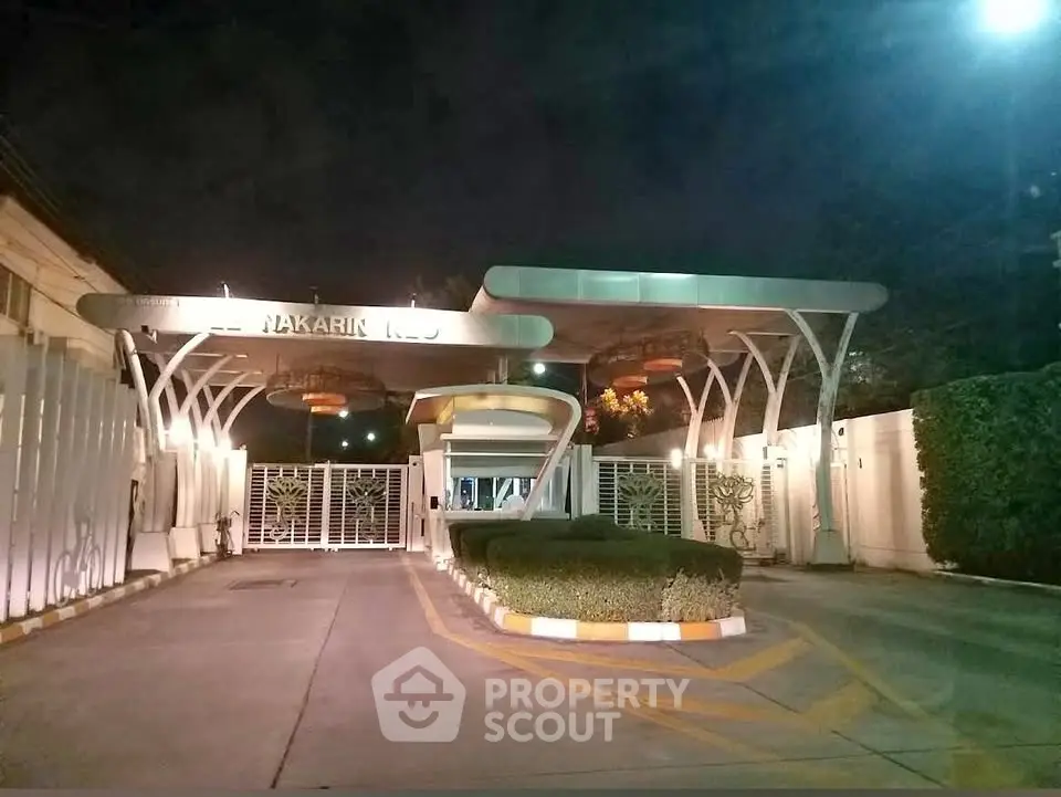 Modern gated entrance with sleek design and ambient lighting at night.