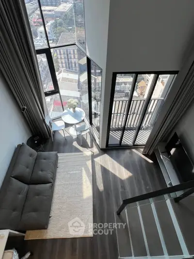 Stunning loft apartment with floor-to-ceiling windows and balcony offering breathtaking city views.