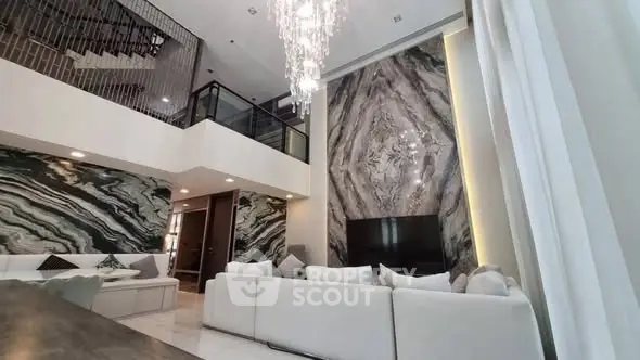 Luxurious modern living room with high ceilings and elegant chandelier