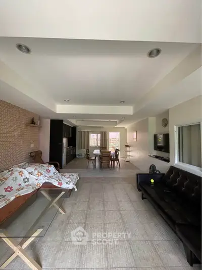 Spacious open-plan living room with modern decor and ample natural light.