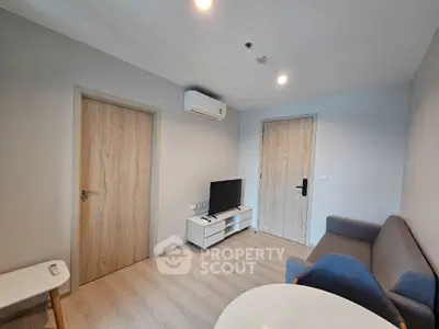 Modern living room with minimalist design, featuring a sleek TV setup and cozy seating area.