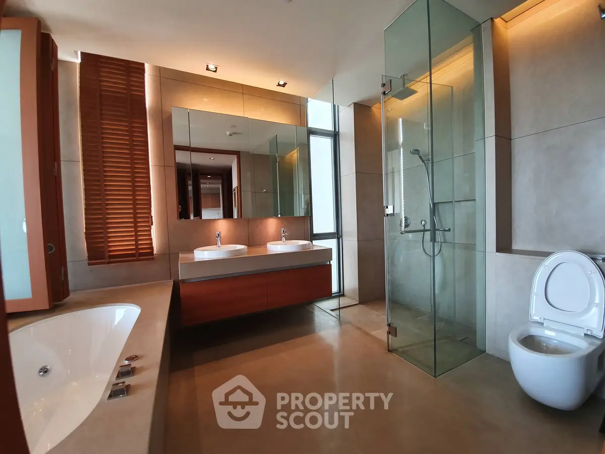 Luxurious modern bathroom with glass shower and bathtub in elegant home.