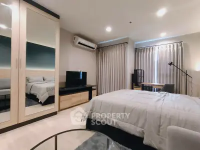 Spacious modern bedroom with mirrored wardrobe and cozy decor