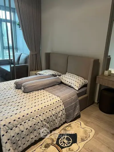 Cozy bedroom with modern decor and large window for natural light.