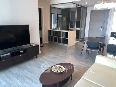 Modern living room with open kitchen, sleek furniture, and stylish decor