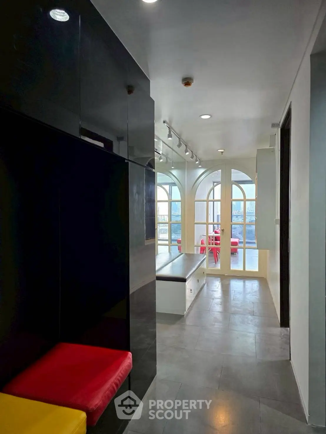 Modern interior with colorful seating and large windows offering city views