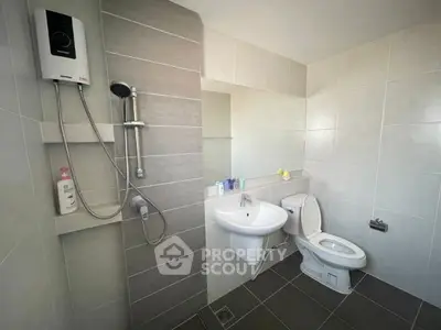 Modern bathroom with sleek tiles and shower unit, featuring a clean and minimalist design.