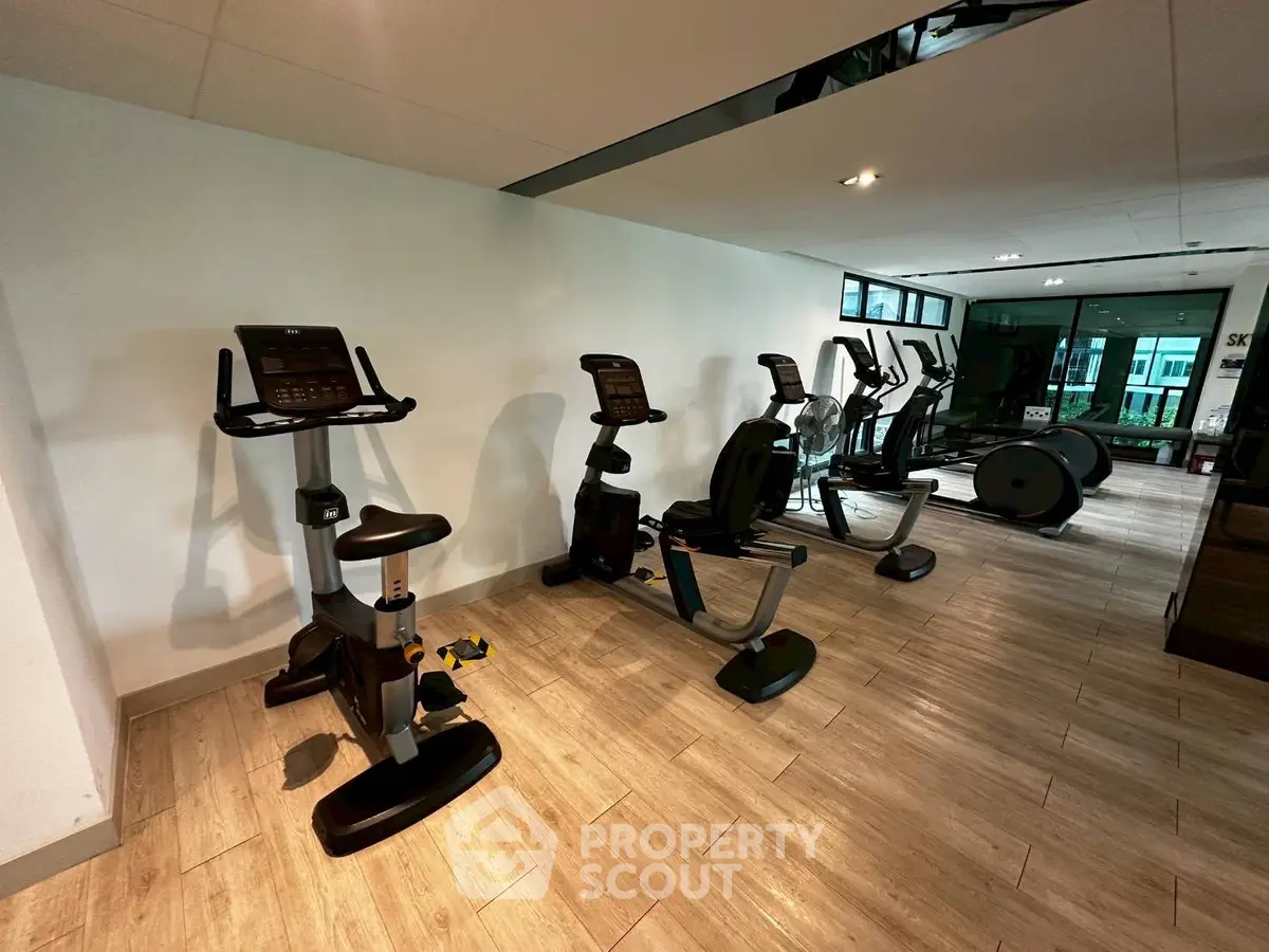 Modern gym with exercise bikes and fitness equipment in a stylish residential building.