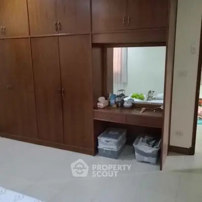 Spacious bedroom with built-in wooden wardrobe and cozy decor