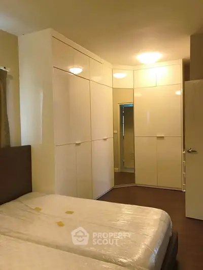 Spacious bedroom with modern built-in wardrobes and twin beds, perfect for comfortable living.