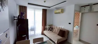 Modern living room with stylish decor and natural light, featuring a cozy sofa and elegant curtains.