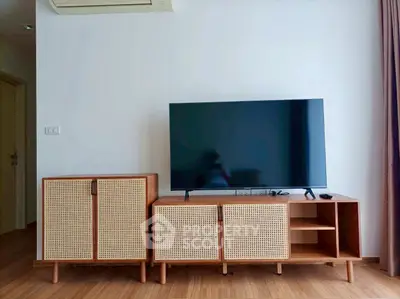Modern living room with stylish TV stand and flat-screen TV, featuring minimalist wooden furniture.