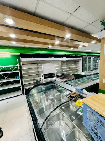 Spacious commercial retail space with modern shelving and display units, ideal for grocery or convenience store setup.