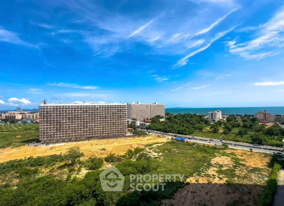 Stunning coastal view with modern high-rise building and lush greenery, perfect for luxury living.