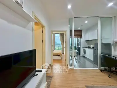 Modern apartment interior with open kitchen and cozy living area, featuring a view of the bedroom and balcony.